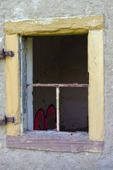 Old open and broken window on wall