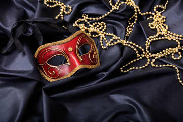 Carnival mask isolated on black satin background, copy space