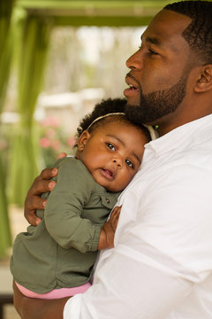 African American father holding his daughter.