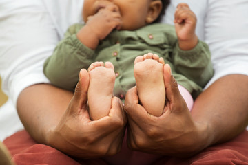 Father holding his daughters little feet.