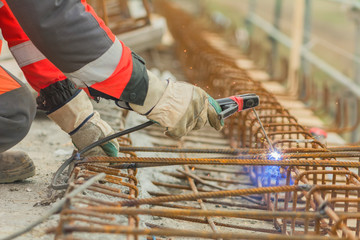 Worker welding armature on the bridge.Close-up shoot