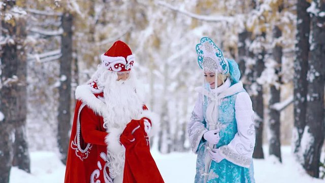 Ded Moroz Father Frost showing Snegurochka Snow Maiden the New Year gifts
