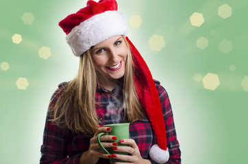 Gorgeous brunette girl wearing Santa's hat and holding hot drink, beautiful bokeh background