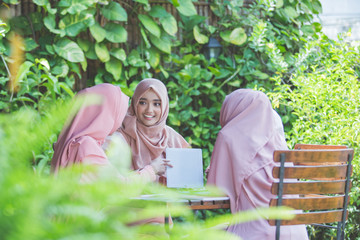 student using tablet pc in cafe with friends