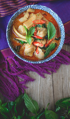 Thai Chicken Red Curry on Thai Fabric and  Old Wooden Background