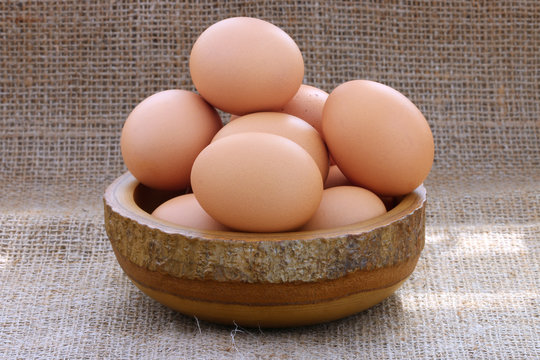 eggs in wooden bowl on sackcloth background