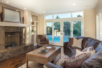 Interior of a Luxury home with leather couch and black marble framed fire place.