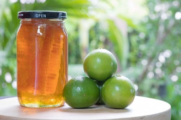 Honeycombs in glass jar and lime on wood table natural backgroun