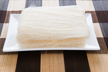 Close-up of white rice noodles on a white plate. rice vermicelli