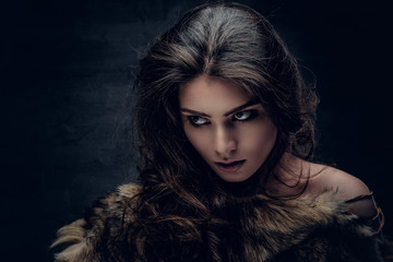 Sensual brunette female dressed in a fur coat.