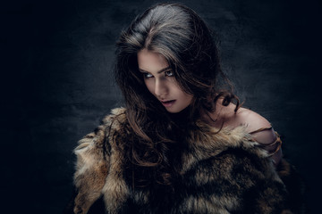 Brunette woman with long curly hair dressed in a fur coat.