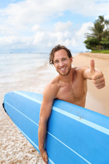 Surfer guy happy with surf surfing smiling doing thumbs up hand sign at camera after fun surf...