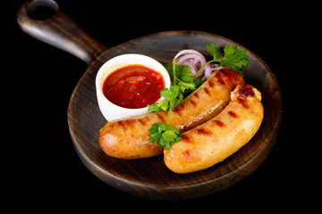 grilled sausage with sauce on black