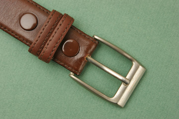 leather belt with a buckle on a green background