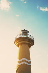 Lighthouse on blue sky with birds in sunset time, vintage tone
