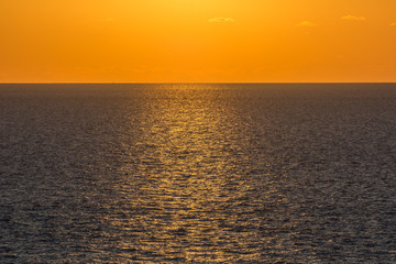 Obraz premium Golden stripe over the sea on a clear sunset