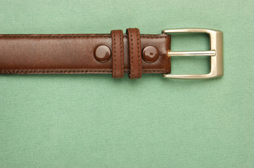 leather belt with a buckle on a green background