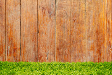 Green grass over wood background.
