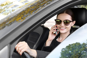 Beautiful woman with cellphone driving a car