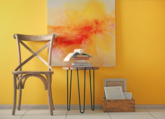 Stylish chair with decorations on yellow wall background