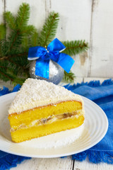 Gentle sponge cake with creamy banana layer, sprinkle coconut on top. Option festive dessert. Close-up.