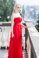 Beauty Blond model woman in evening red dress.