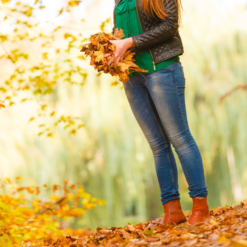 Girl is about to throw leaves up.