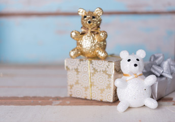 Christmas cute gold teddy bear and golden gift box on wooden bac