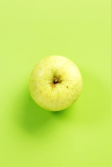 Green apple on green background.Useful as a food background