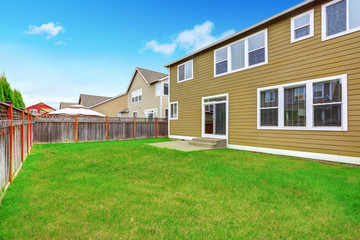 Obraz premium Green olive siding house exterior. Grass filled back yard.