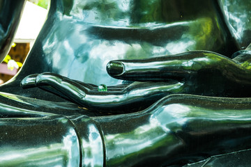 Hand of black buddha with glass ball