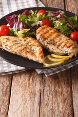 Healthy food: grilled chicken and mix salad of chicory, tomatoes, kale and lettuce close-up. vertical