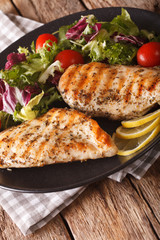 Grilled chicken breast with salad of chicory, tomatoes and lettuce close-up. vertical