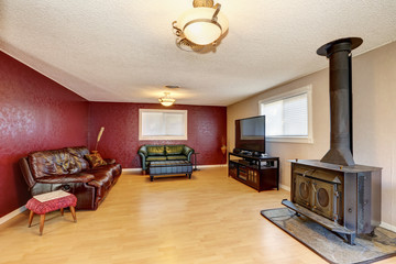 Contrast red wall in the living room with antique fireplace.
