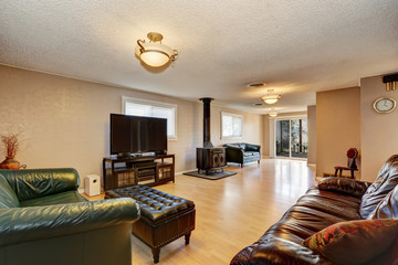 Living room with antique fireplace, leather sofas and ottoman