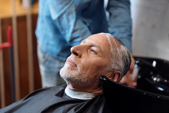 Old Man During Washing His Hair In Barber Shop