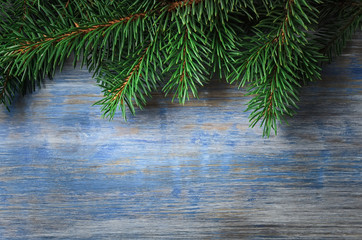 Christmas background. Green spruce tree on the background of old wooden board. Top view.