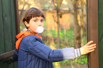 preteen handsome boy with chewing gum bubble