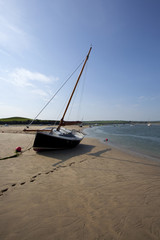 Boats left stranded by the falling tide on the River Camel, Cornwall, UK