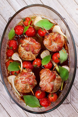 Meat rolls on scewers with cherry tomatoes and garlic. View from above; top studio shot