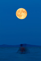 Full moon over the lake on the beach