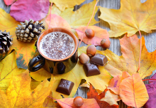 Autumn Cup of coffee, nuts, pine cones, chocolate and autumn leaves