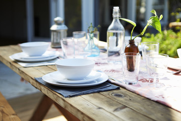 Fototapeta na wymiar Table Set For Outdoor Meal On Wooden Table In Garden