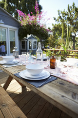 Table Set For Outdoor Meal On Wooden Table In Garden