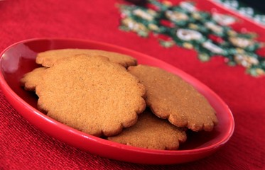 Gingerbread cookies on red christmas plate.