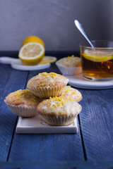 Aromatic Homemade Lemon and Poppy seed Muffins with cup of tea on the wooden background. 