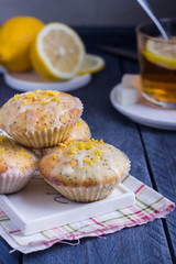 Aromatic Homemade Lemon and Poppy seed Muffins with cup of tea on the wooden background. 