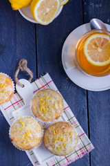 Aromatic Homemade Lemon and Poppy seed Muffins with cup of tea on the wooden background. 