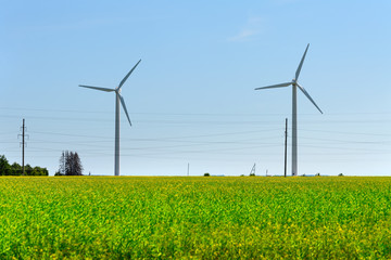 Fototapeta na wymiar Wind generator in the meadows, on a background of blue sky.