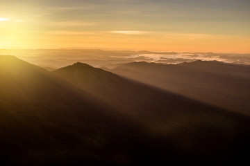 Fototapeta na wymiar beautiful sun rise on top mountain with sun ray warm tone